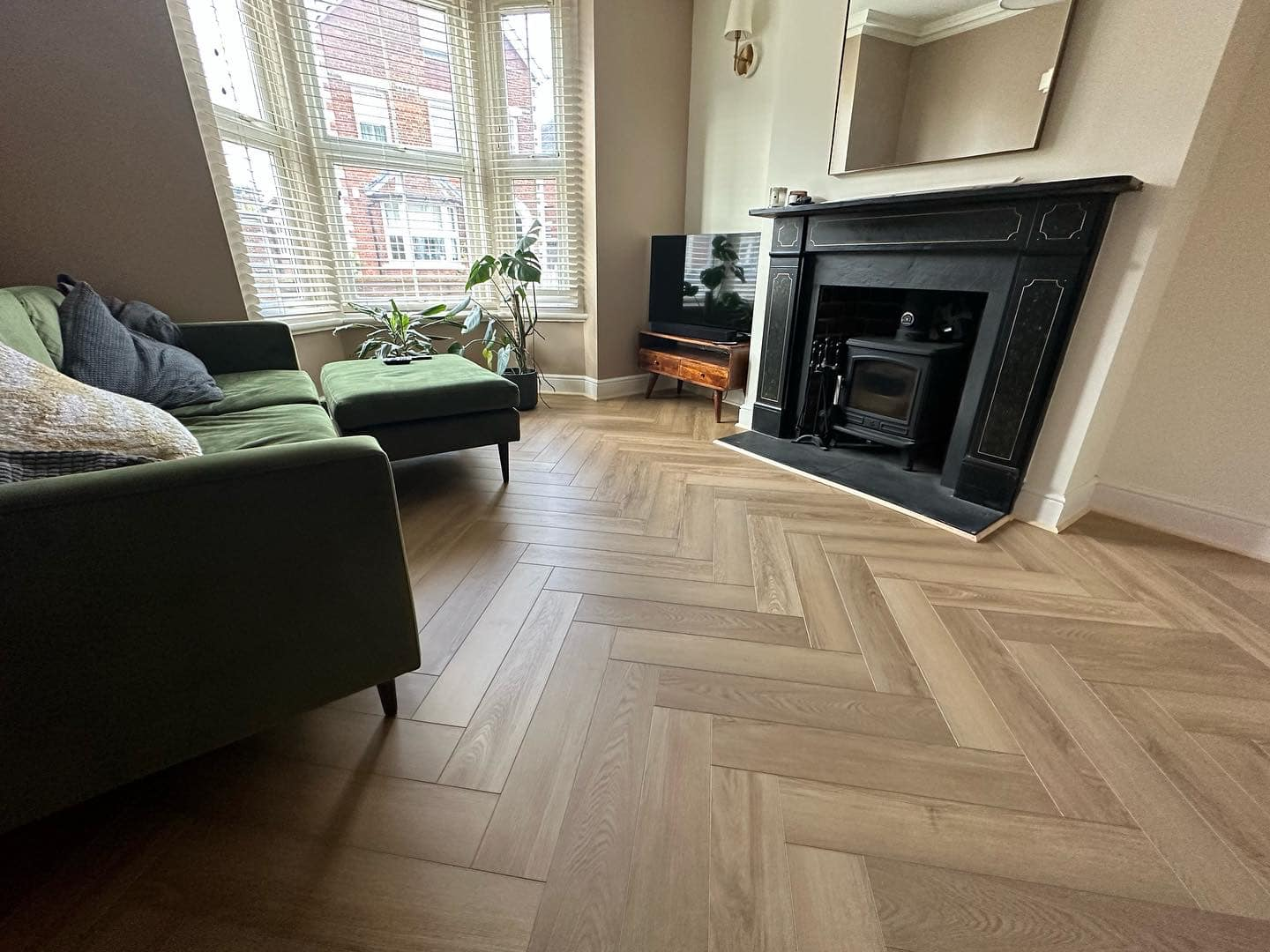 Light herringbone parquet living room with log burner
